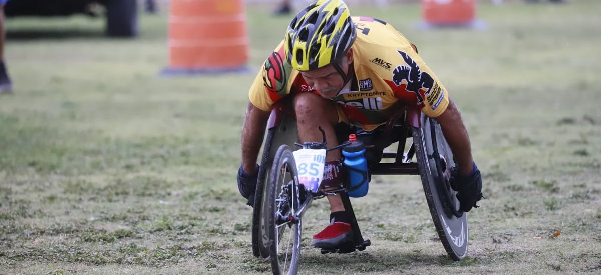 Determined wheelchair racer competing in an outdoor marathon, displaying focus and athleticism.